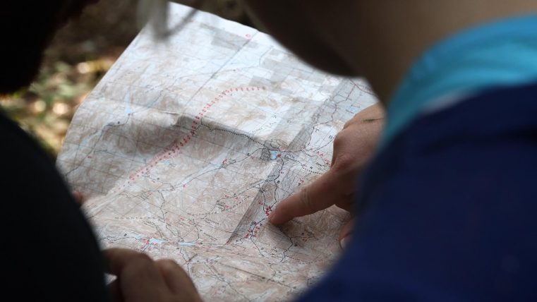 Deux personnes examinent une carte en essayant de comprendre quelle route prendre.